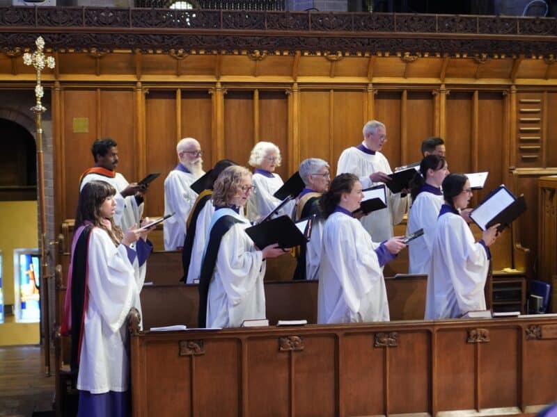 Members of the St. John’s Cathedral choir sing from the choir stalls during worship in Denver.