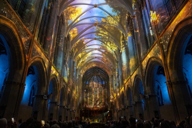Celestia Experience illuminating the vaulted interior of St. John’s Cathedral in Denver with immersive projections of light and nature above a seated audience.