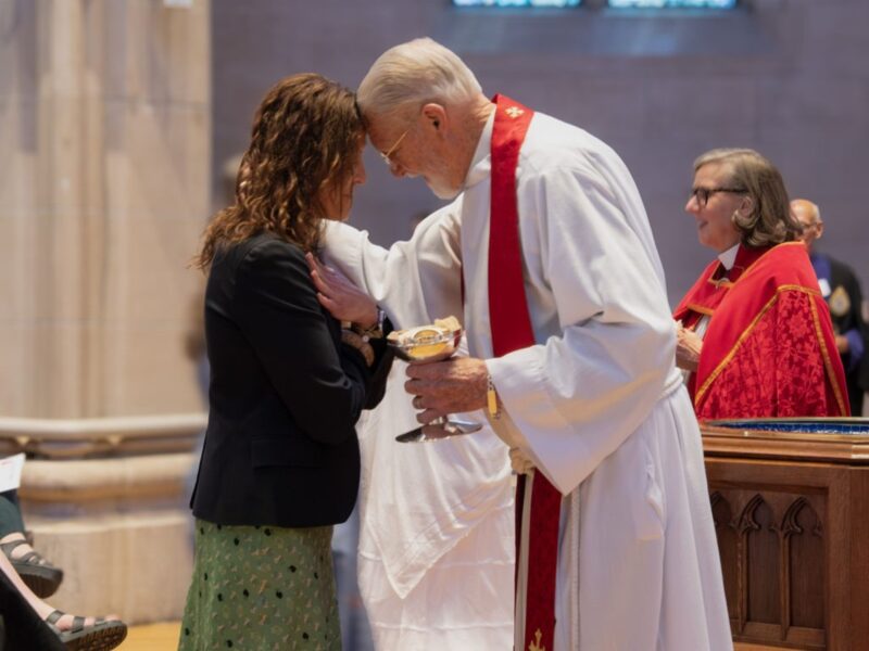 A worshiper receives Holy Communion from clergy during a service at St. John’s Cathedral in Denver.