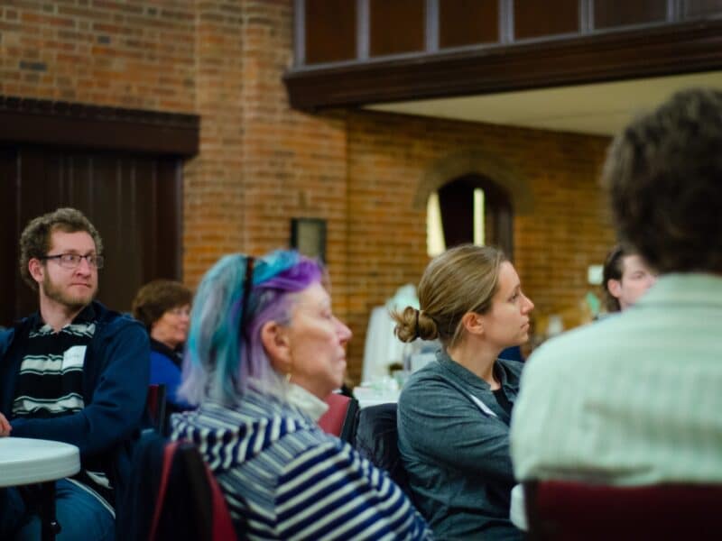 Adults gather in conversation during a SAGES spiritual formation group at St. John’s Cathedral in Denver, exploring faith and spiritual growth in community.