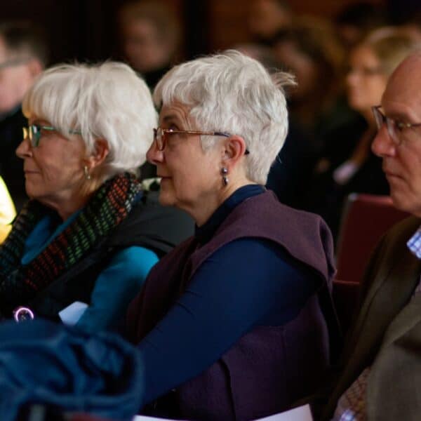 Adults seated together and listening during an annual meeting at Saint John’s Cathedral.